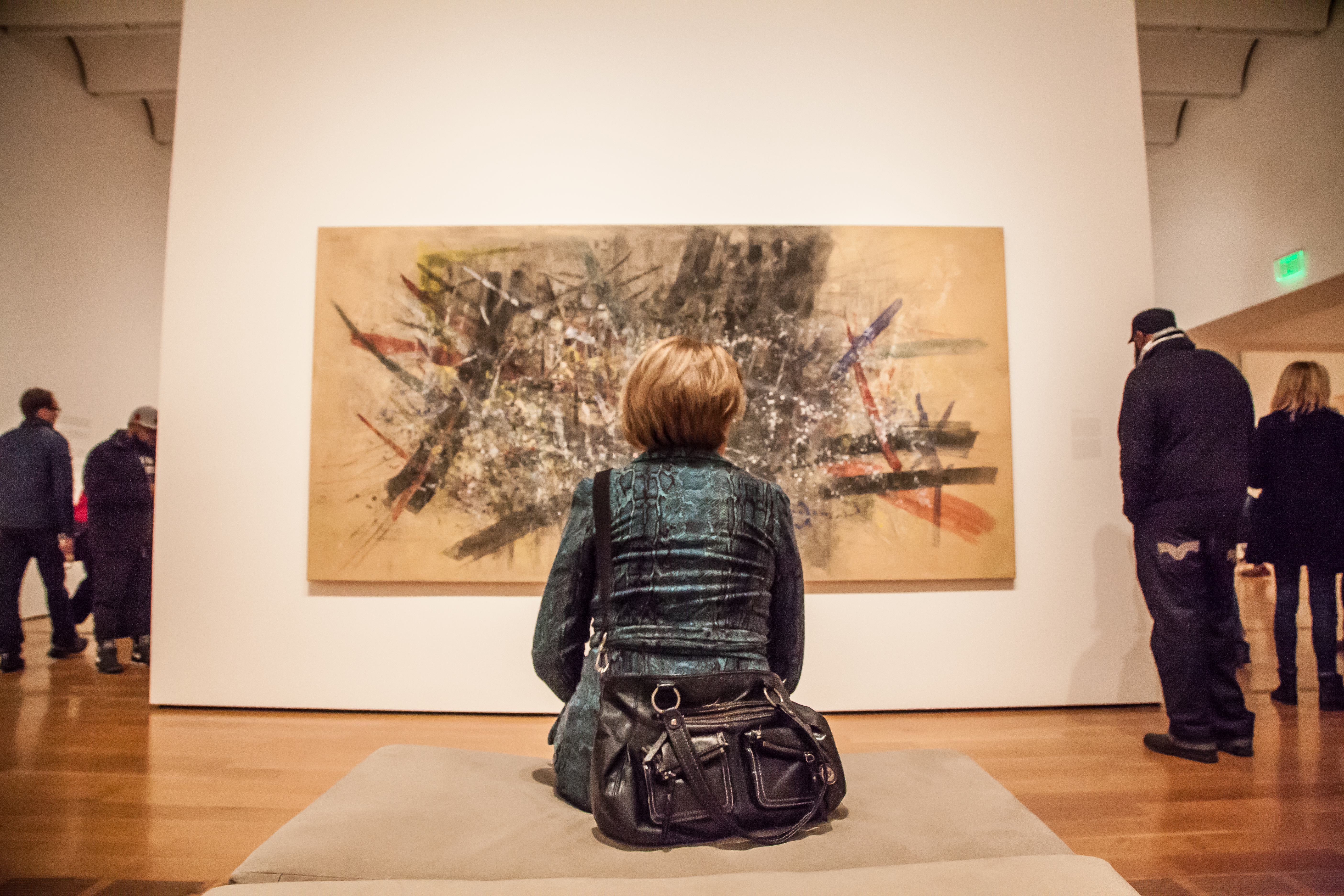Woman sits in front of painting at the High Museum of Art
